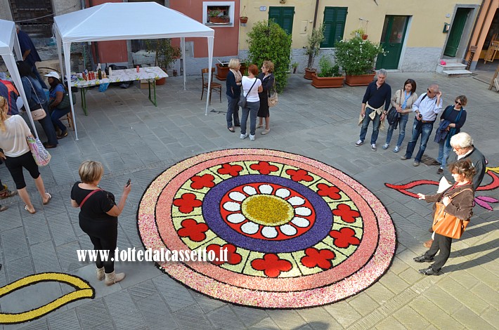 BRUGNATO (Infiorata del Corpus Domini 2013) - Disegno circolare in Via Riva d'Armi allestito con petali di fiori sminuzzati. I contorni neri sono fatti con fondi di caff