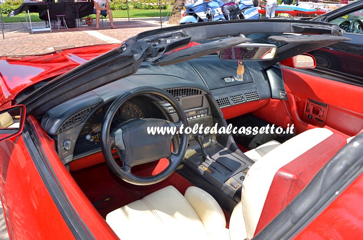TUNING - Posto guida e interni in tinta rosso/nero di una CHEVROLET Corvette con sedili in pelle bianca