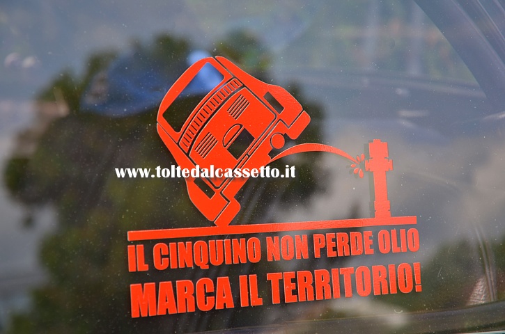 TUNING - Slogan perentorio sul vetro posteriore di una Fiat 500 che recita: "Il Cinquino non perde olio, marca il territorio!"
