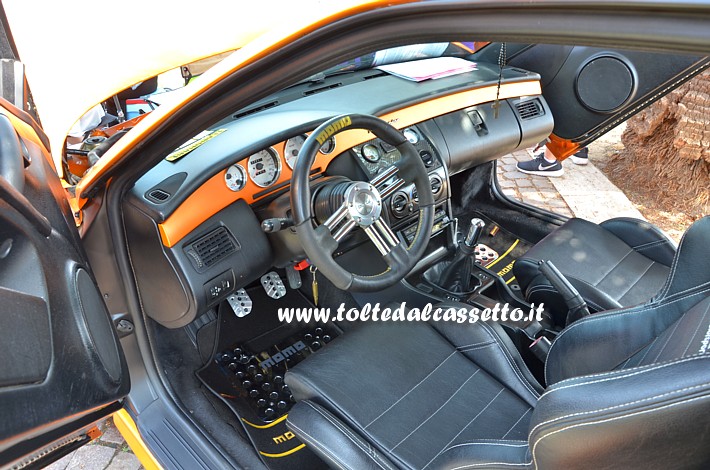 TUNING - Fiat Coup con selleria in pelle nera, volante Momo e vertical doors. La strumentazione primaria del cruscotto  inserita in una banda di colore arancio