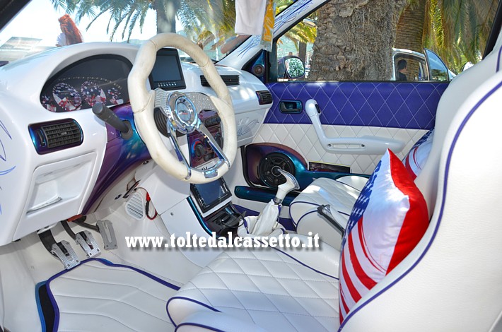 TUNING - Una raffinata FIAT Punto con cruscotto bianco, selleria in pelle trapuntata bianca con rifiniture blu. I cuscini sui sedili mostrano il disegno, quasi fedele, della bandiera USA
